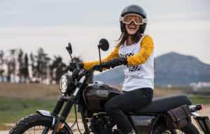 Laughing young woman sitting on a Cromwell 125 in Charly Brown